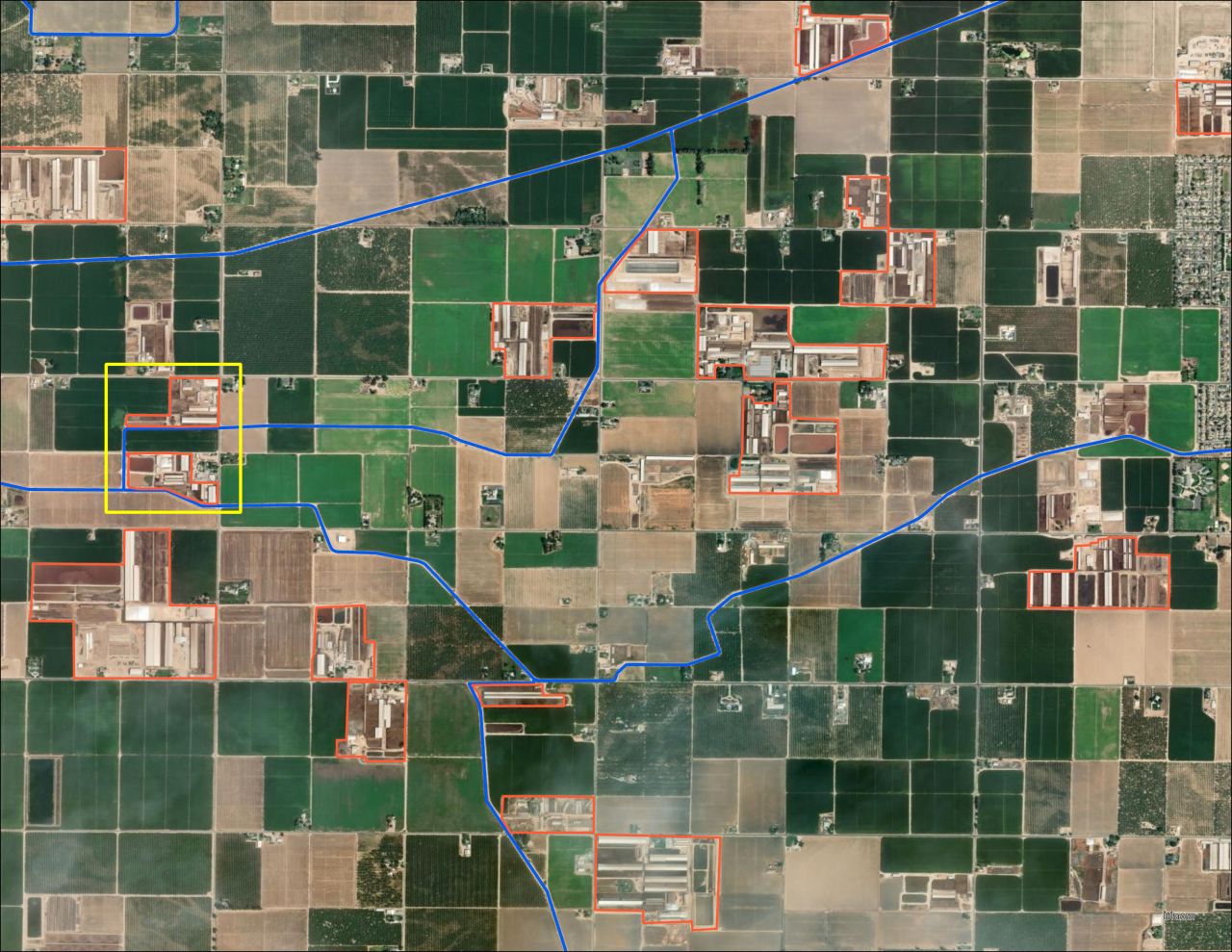 Two animal facilities next to irrigation canals in the Central Valley, with facilities outlined in orange and irrigation canals indicated by blue.