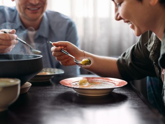 Woman and man eating soup